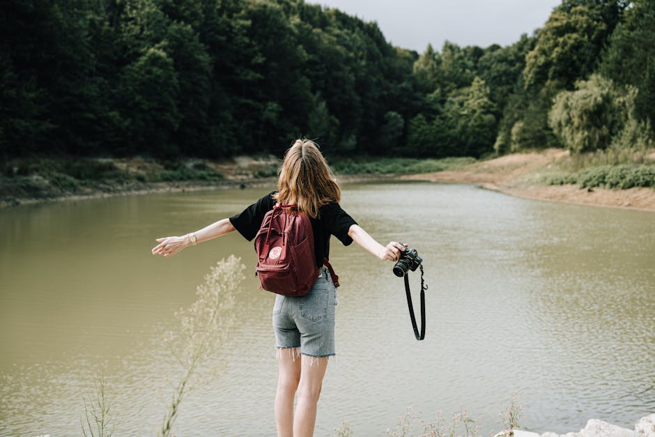 A smiling woman engages in outdoor physical activity, surrounded by nature and serene landscape, promoting wellness and self-care.